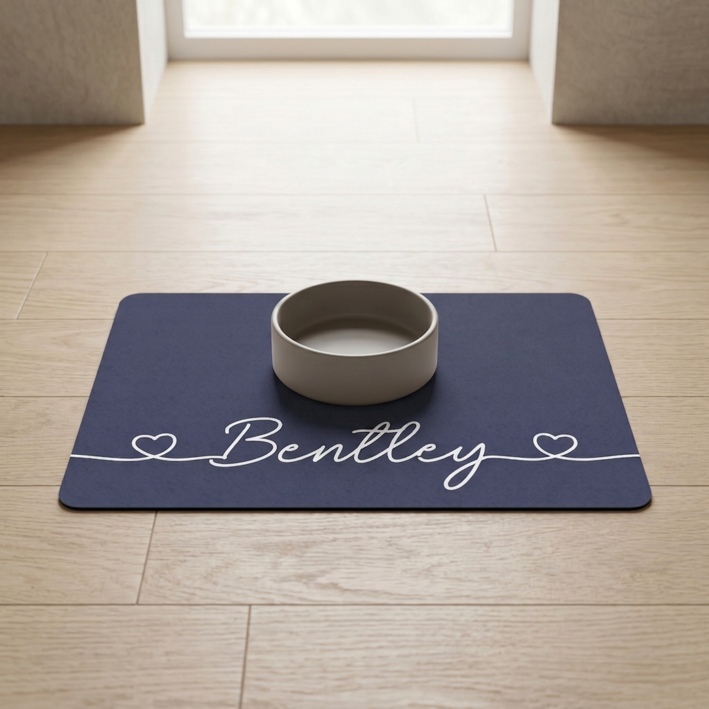 Navy blue dog food mat with a white bowl on a wooden floor