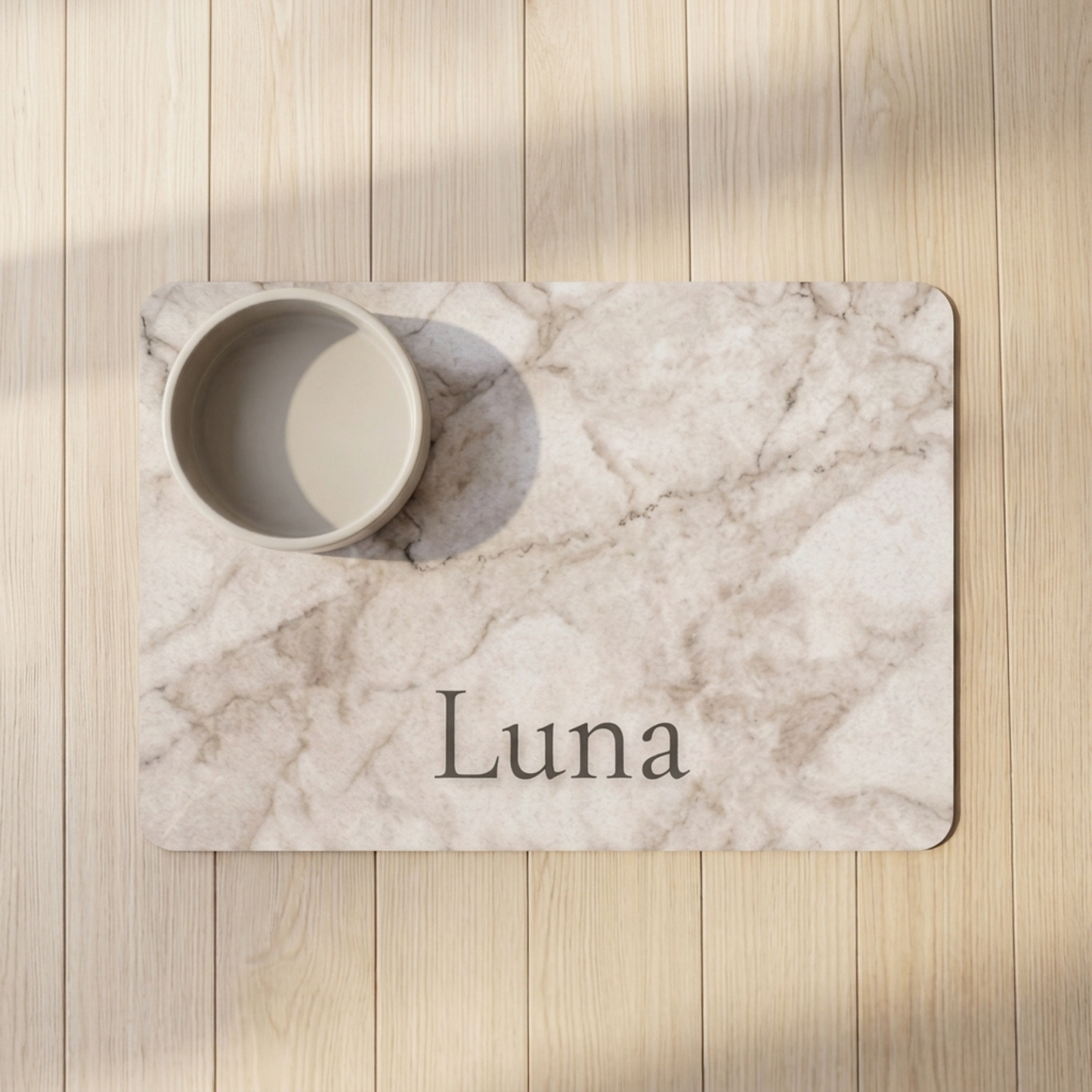 Marble-patterned placemat with 'Luna' printed on it, placed on a wooden surface.
