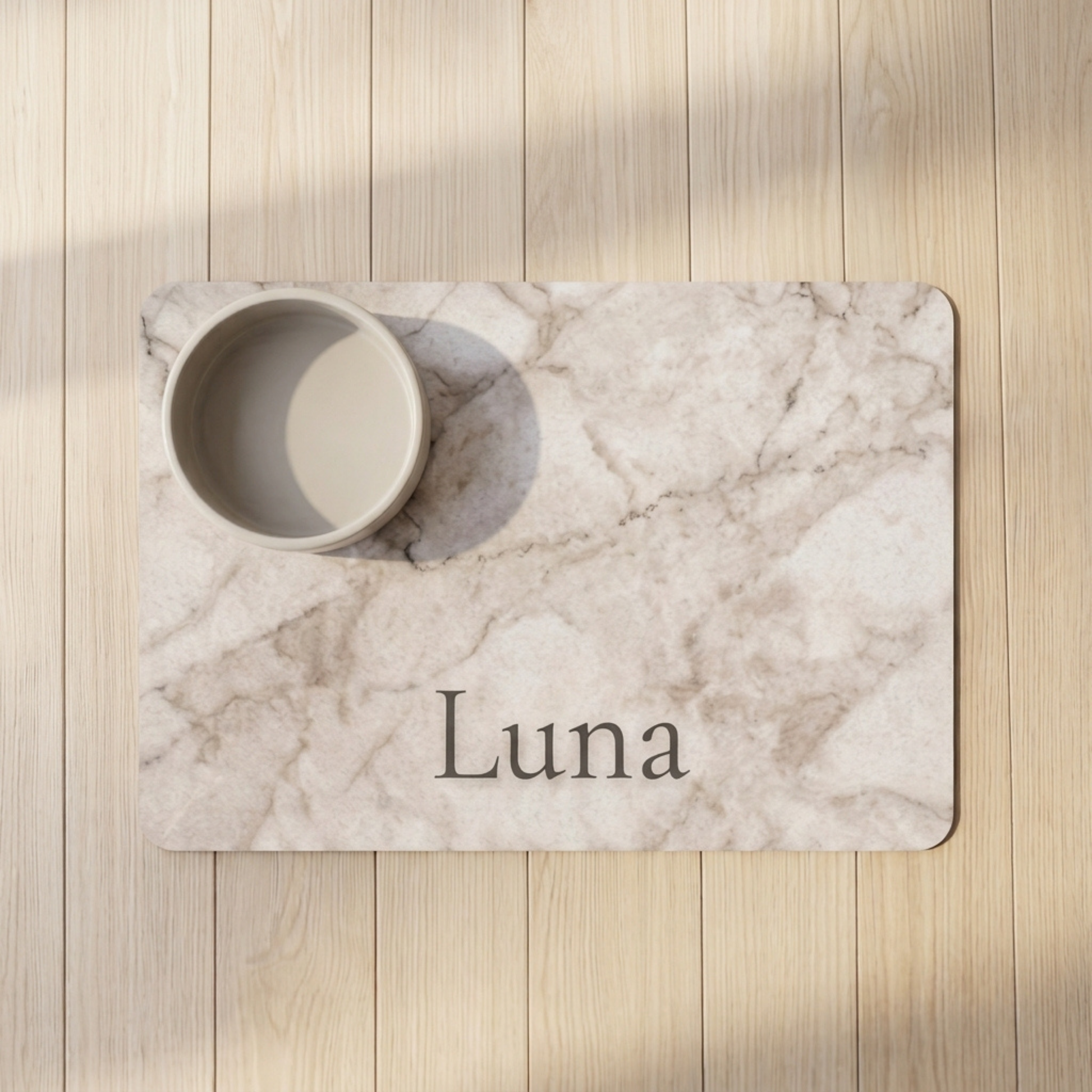 Marble-patterned placemat with 'Luna' printed on it, placed on a wooden surface.