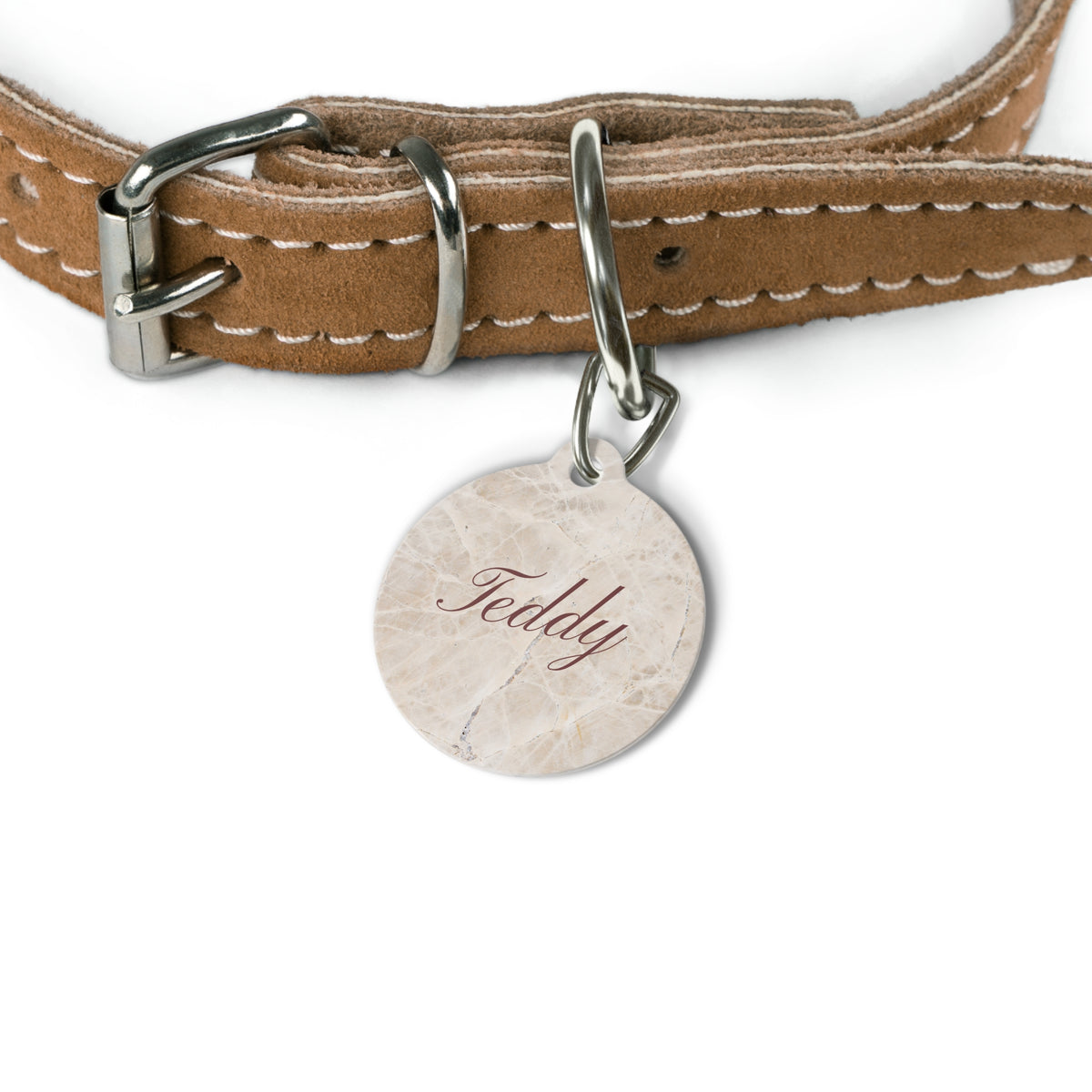 Beige marble name tag attached to a tan leather dog collar