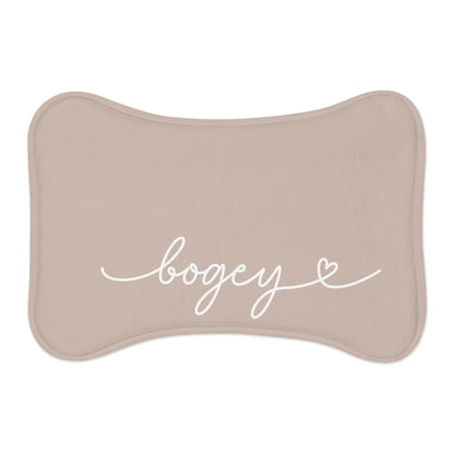 Beige bone-shaped personalized pet feeding mat with the name Bogey in white handwritten script and a small heart