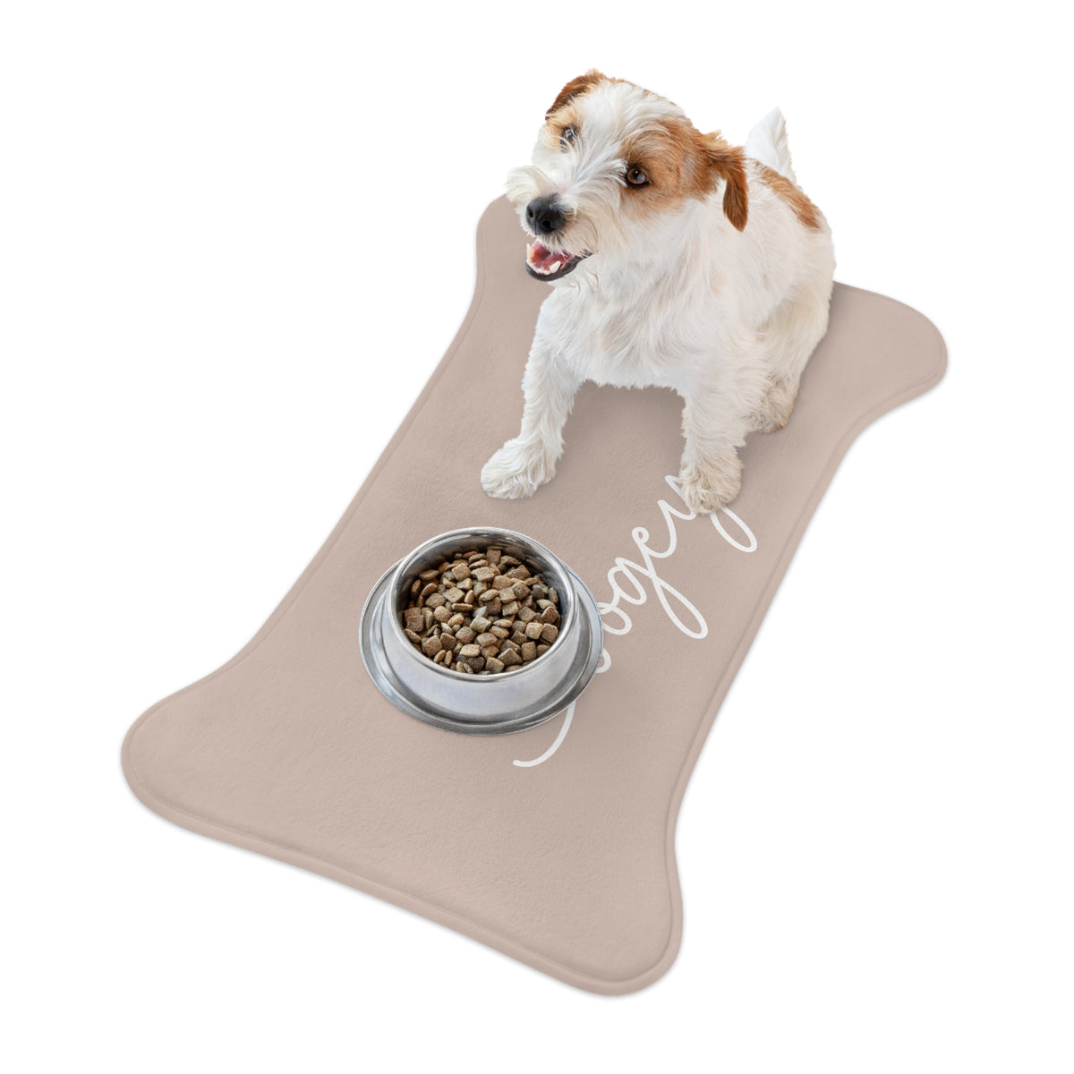 Jack Russell terrier standing on a beige bone-shaped personalized pet feeding mat next to a food bowl