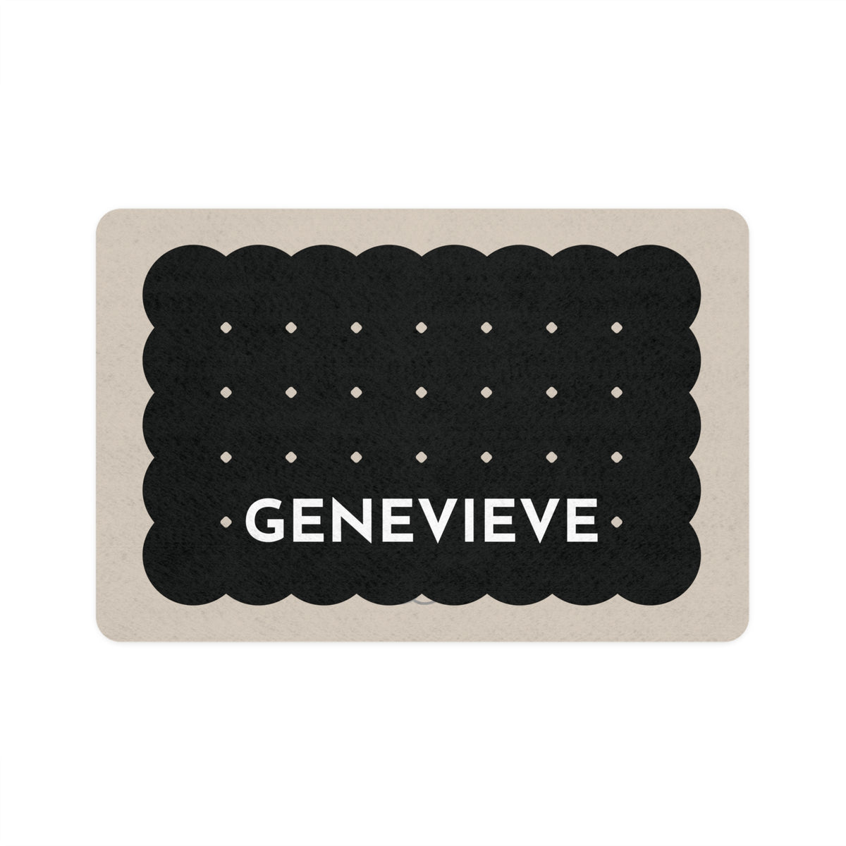 Black biscuit personalized dog food mat shaped like a scalloped cookie with dots and the name Genevieve on a sand background