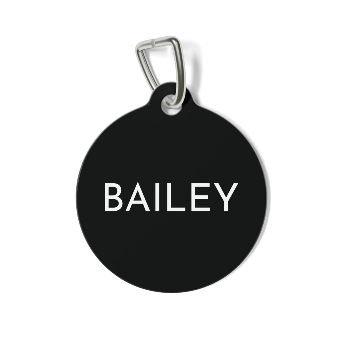 Round black modern personalized dog tag with the name in clean white capital letters