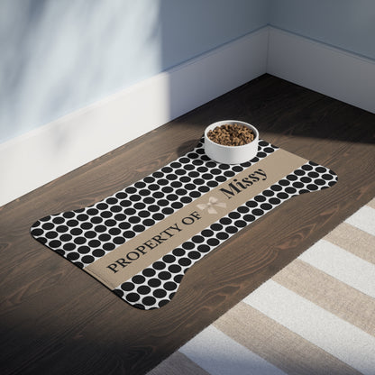 Black polka dot personalized pet feeding mat with a bowl on a dark wooden floor
