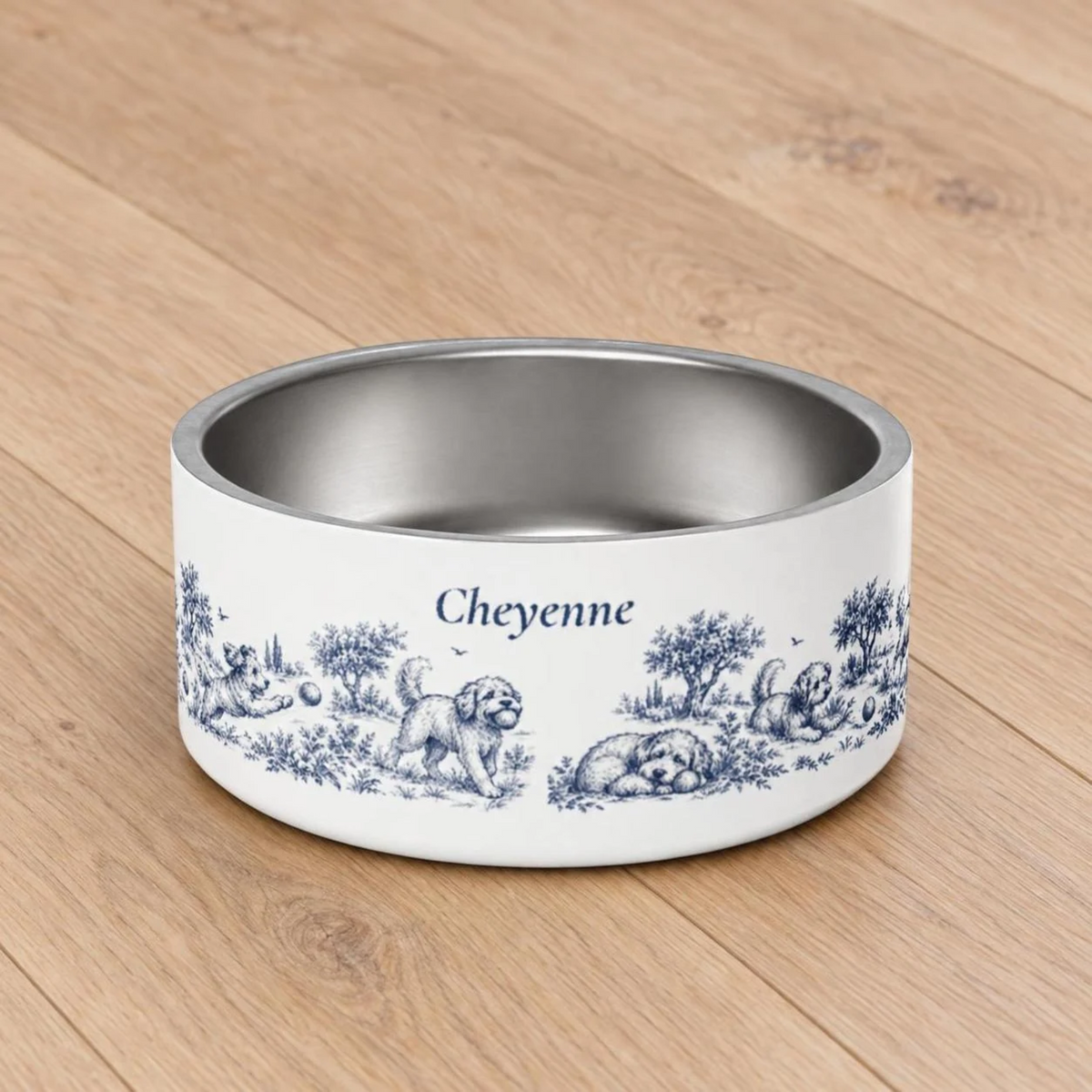 Top view of an empty blue dog toile personalized dog bowl with the name Cheyenne on a wooden floor