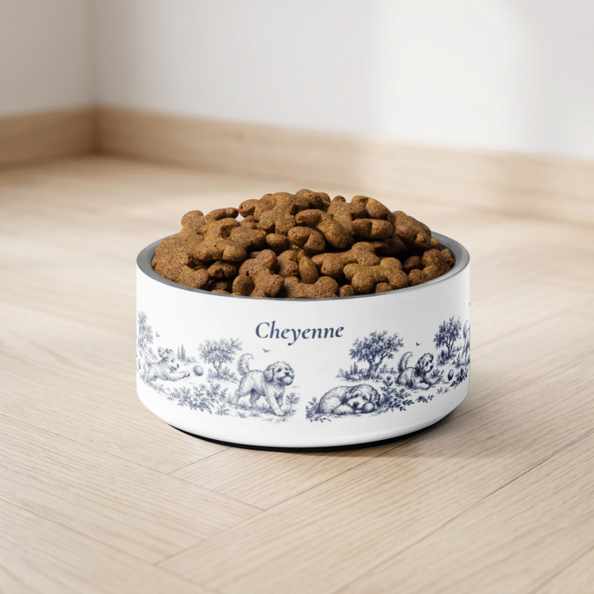 Blue dog toile personalized dog bowl with the name Cheyenne filled with kibble on a light wooden floor