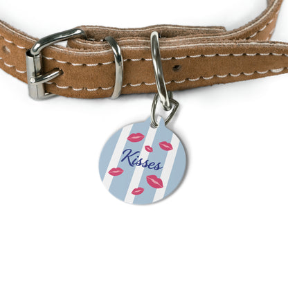 Blue stripe kiss pet tag hanging from a brown leather dog collar