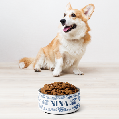 Corgi sitting next to a blue toile personalized dog bowl filled with kibble