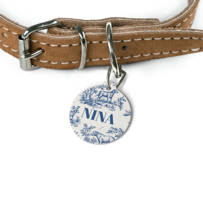 Blue toile name tag attached to a tan leather dog collar
