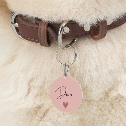 Close-up of the blush heart pet tag hanging from a brown collar on a fluffy dog
