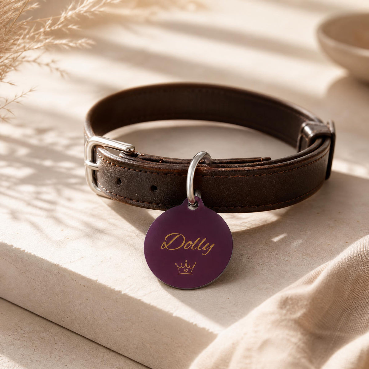Burgundy crown pet tag on a dark brown leather collar