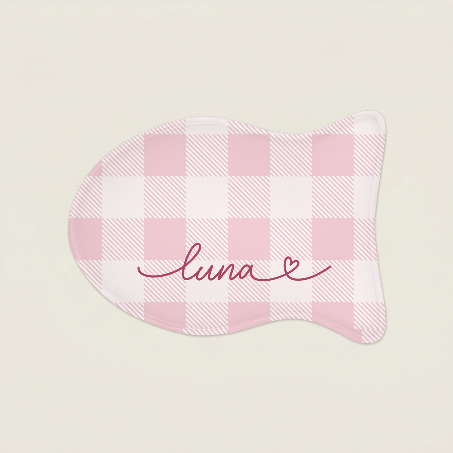 Pink cat food mat with 'luna' embroidery on a light beige background