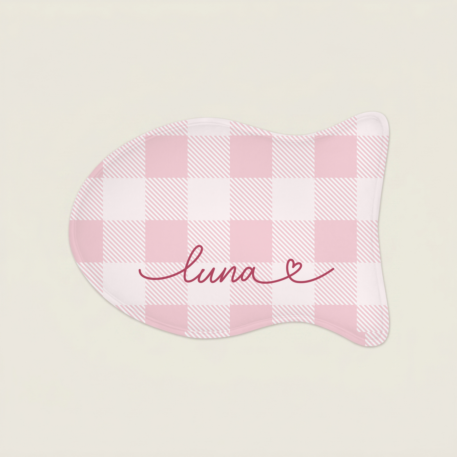 Pink cat food mat with 'luna' embroidery on a light beige background