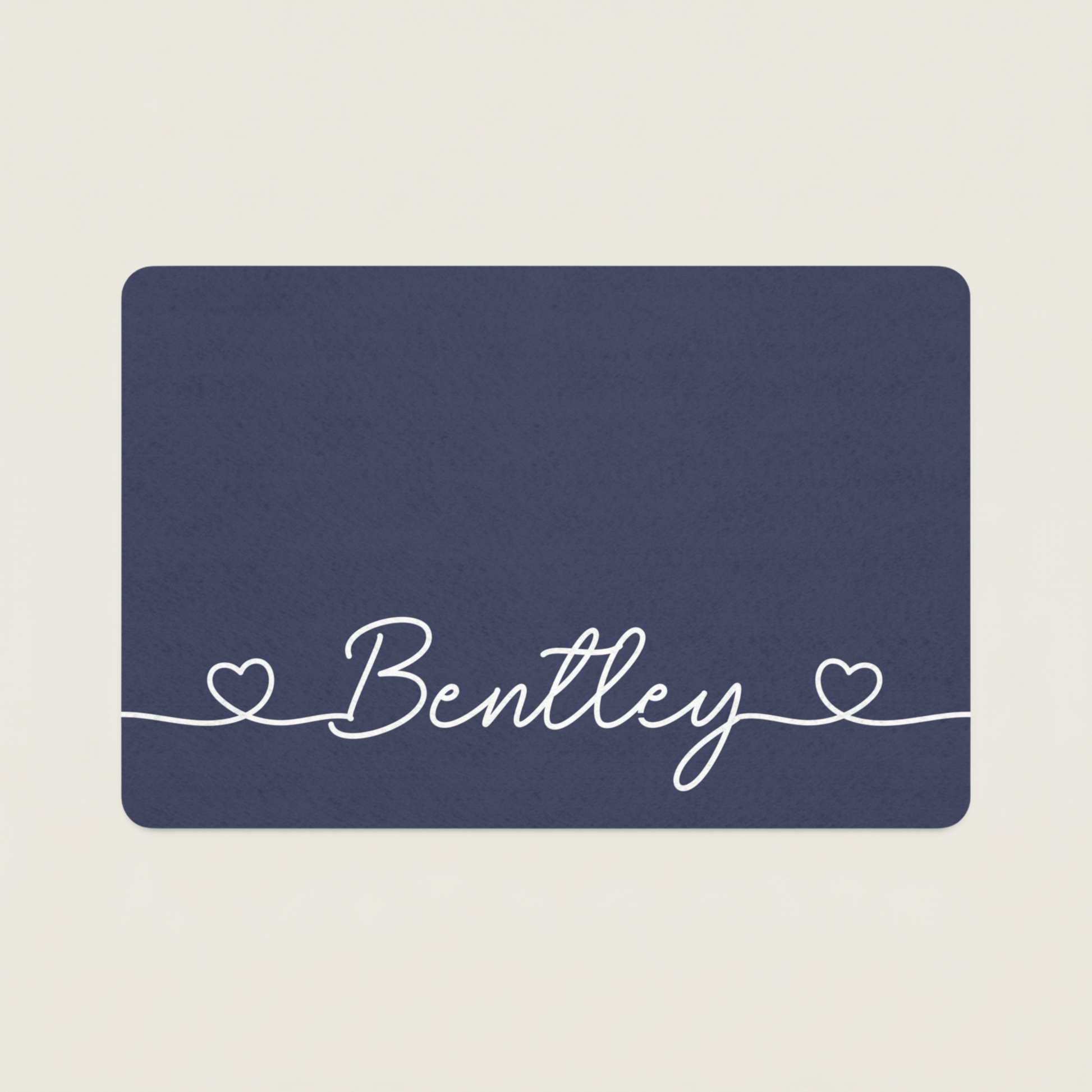 Navy blue dog food mat with 'Bentley' in white cursive text on a beige background