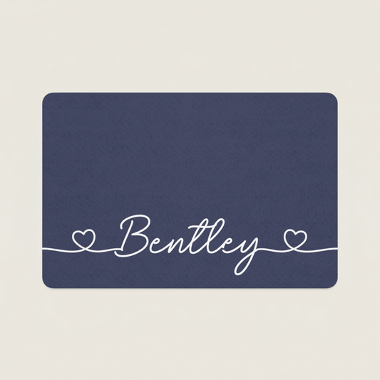 Navy blue dog food mat with 'Bentley' in white cursive text on a beige background