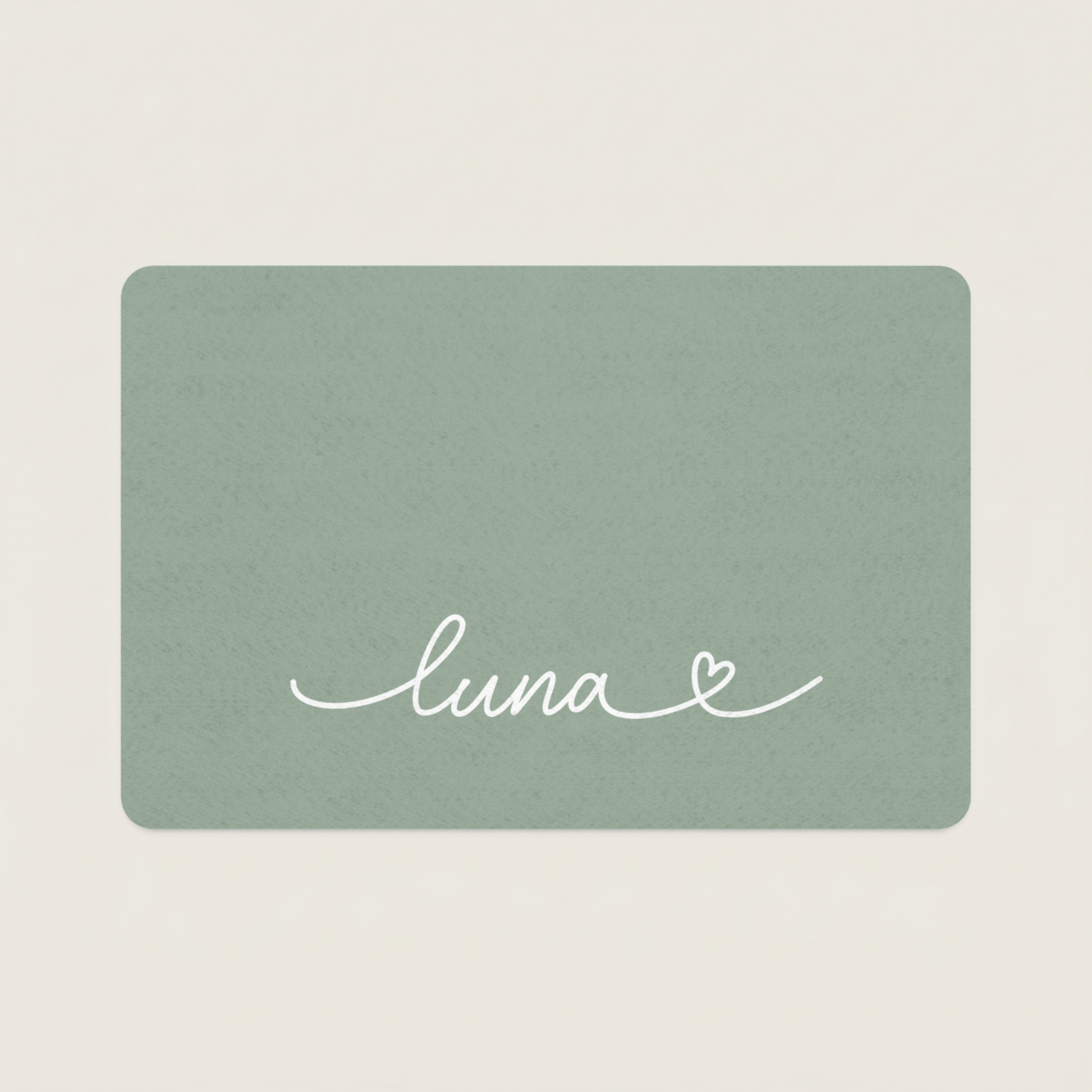 Green dog food mat with name 'luna' and a heart on a beige background