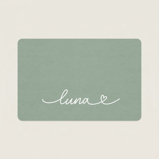 Green dog food mat with name 'luna' and a heart on a beige background