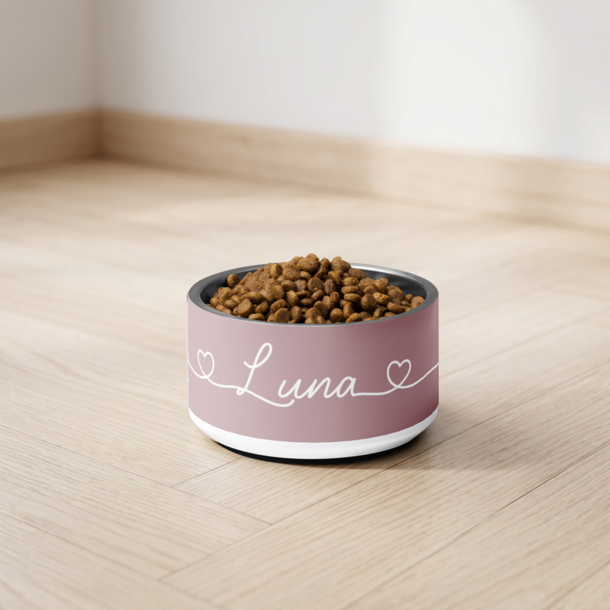 Pet food bowl labeled 'Luna' on a wooden floor