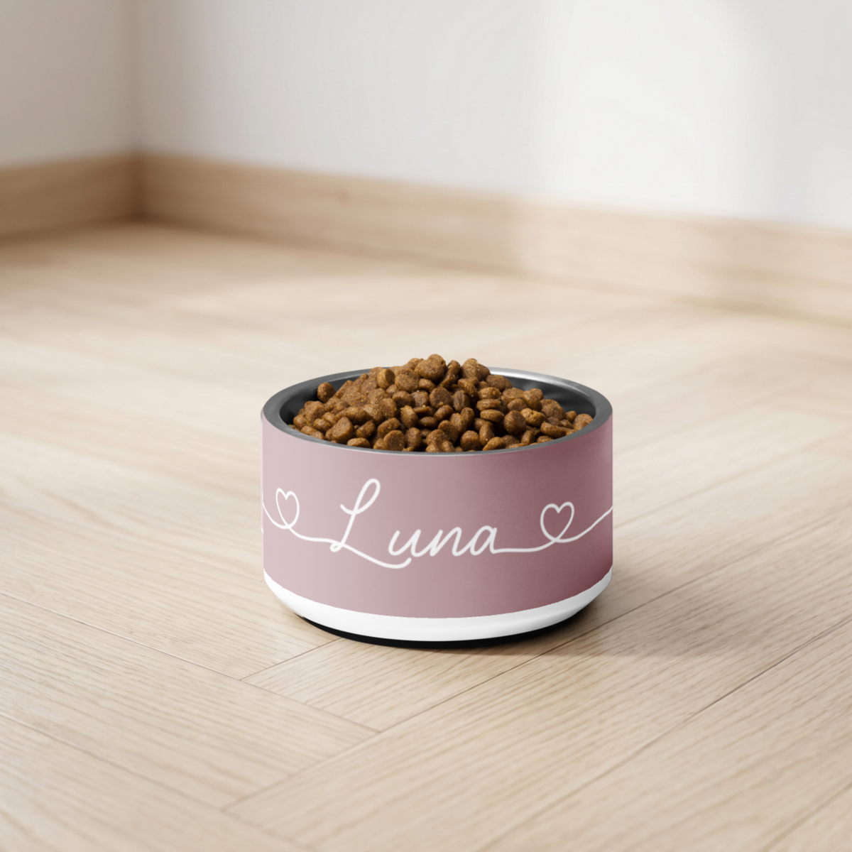 Dusty rose personalized dog bowl with kibble on a light floor