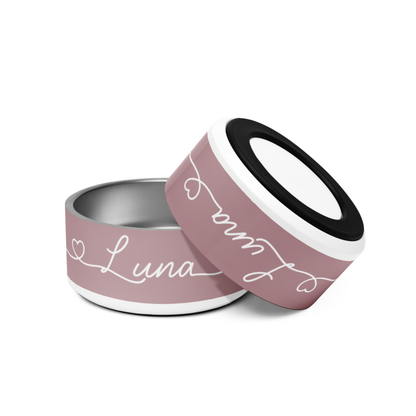 Two dusty rose personalized dog bowls tilted together showing the handwritten names