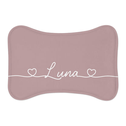Dusty rose bone-shaped personalized pet feeding mat with the name Luna in white script between two small hearts