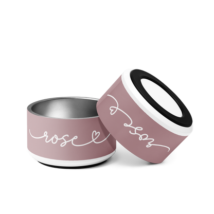 Two dusty rose personalized dog bowls tilted together showing the handwritten name