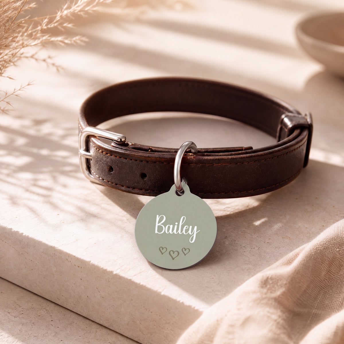 Sage green heart pet tag on a dark brown leather collar