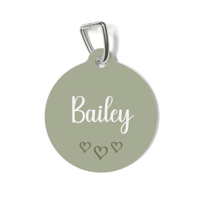 Sage green heart personalized pet tag with the name Bailey in white script and three small hearts