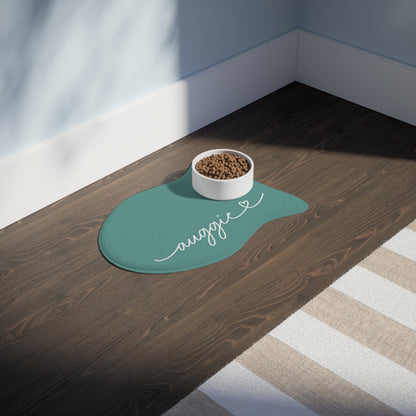 Jade fish-shaped personalized pet feeding mat with a food bowl on a dark wooden floor