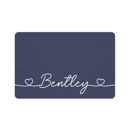 Navy blue rectangle personalized pet food mat with the name Bentley in white handwritten script framed by two hearts