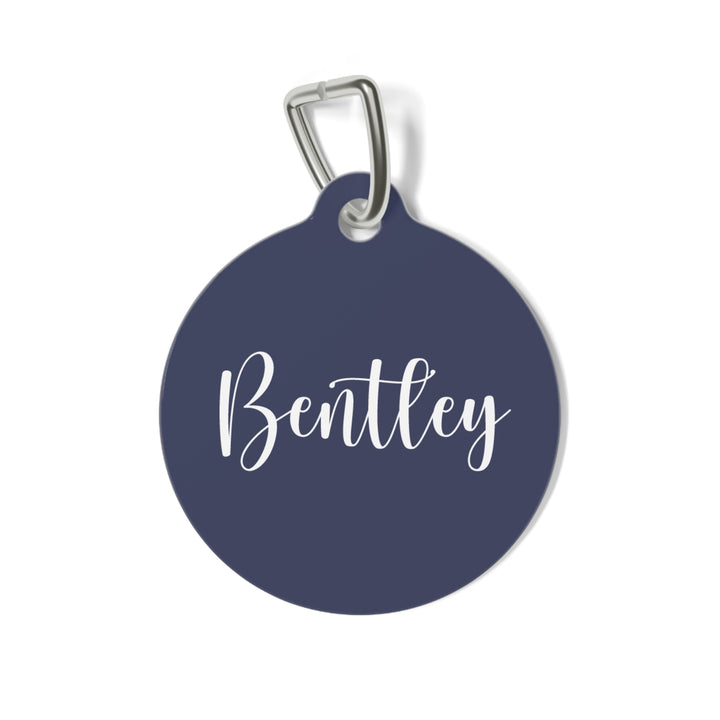 Round navy blue personalized pet tag with the name Bentley in white calligraphy script