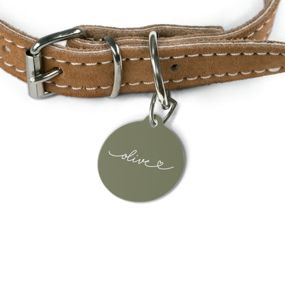 Olive green personalized pet tag hanging from a tan leather dog collar