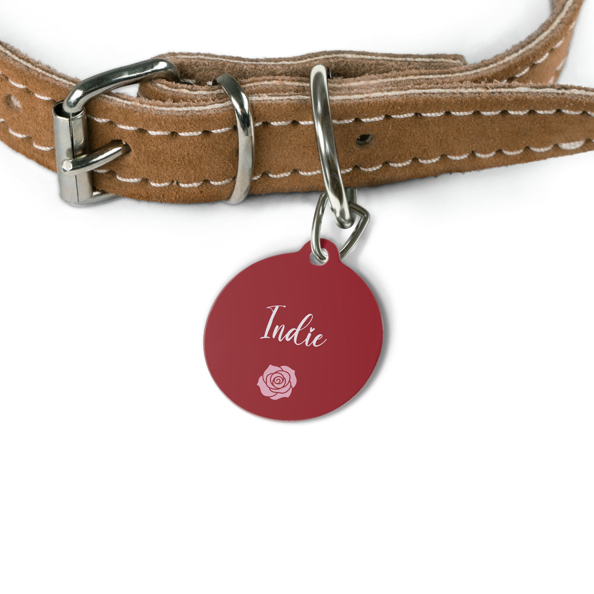 Burgundy name tag attached to a tan leather dog collar