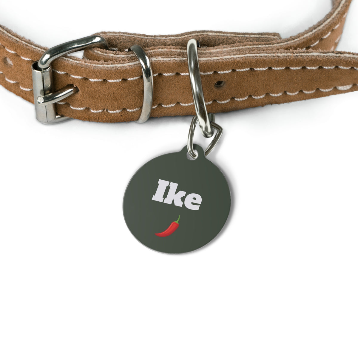 Green personalized name tag attached to a tan leather dog collar