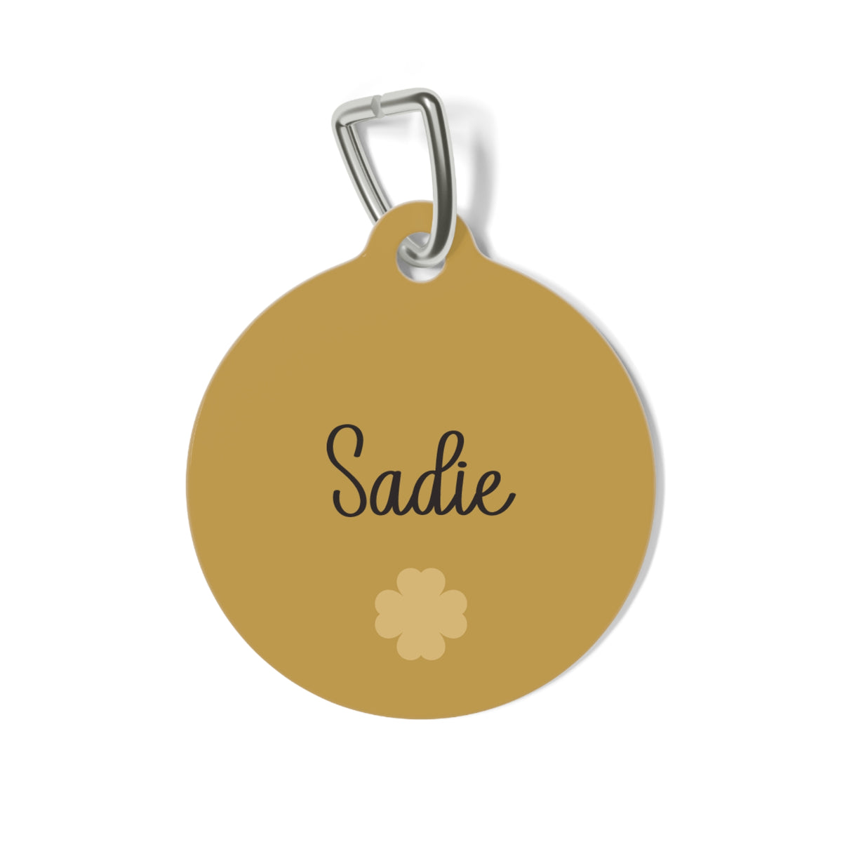 Golden personalized dog tag with the pet name in handwritten script and a small clover