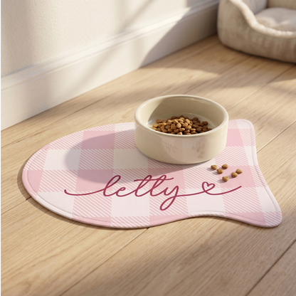 Pink checkered fish-shaped personalized cat feeding mat with the name Letty and a food bowl
