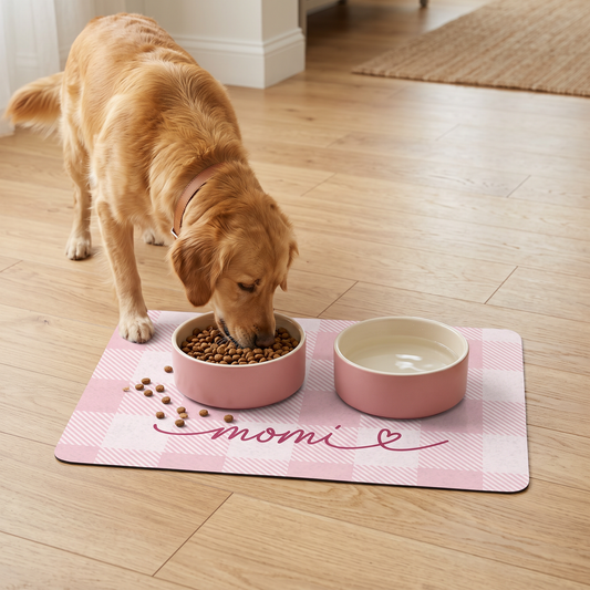Dog eating from pink bowls on a pink checkered personalized pet food mat