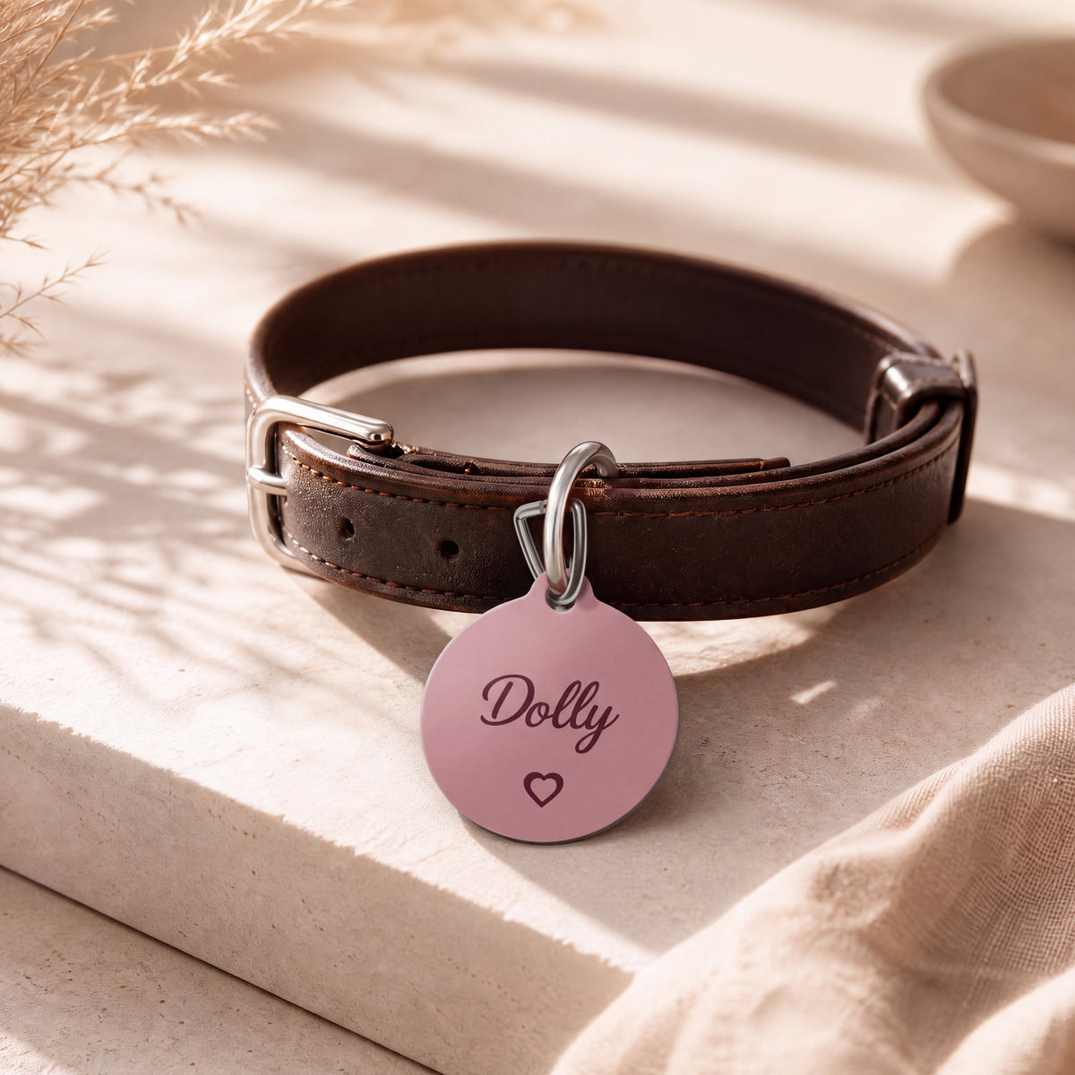 Pink heart pet tag on a dark brown leather collar