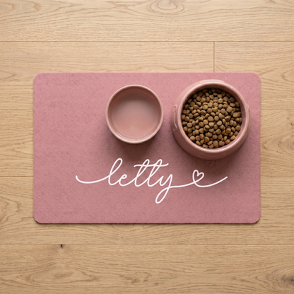 Pink personalized pet food mat with the name Letty holding a food bowl and a water bowl