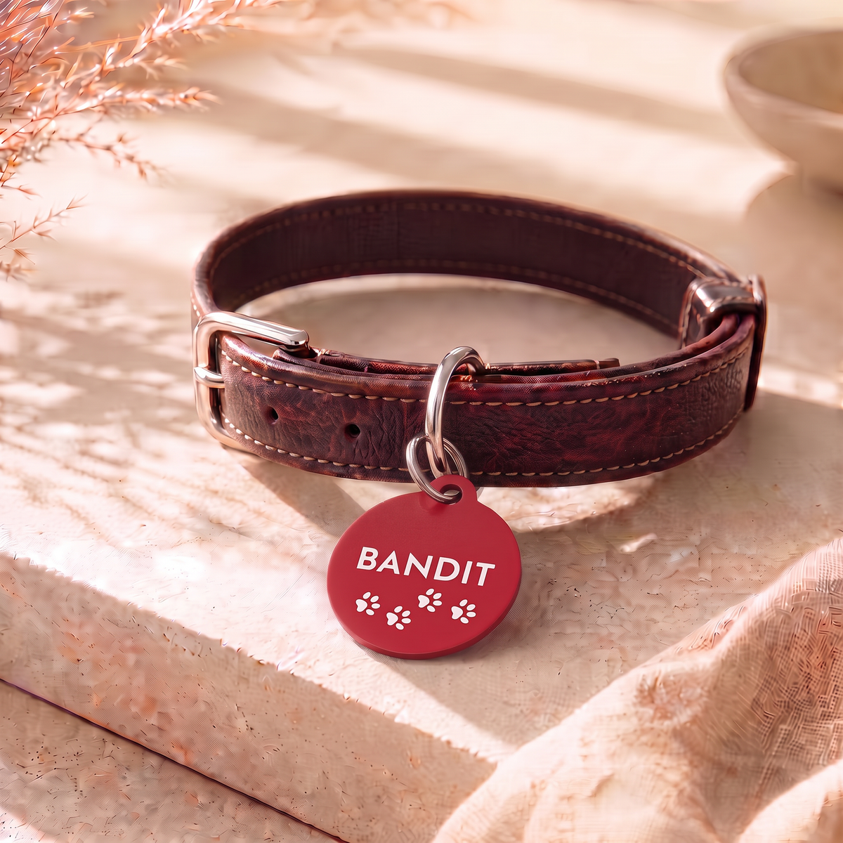 Red personalized dog tag with name Bandit on a dark brown leather collar