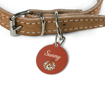Rust pumpkin personalized dog tag hanging from a brown leather dog collar