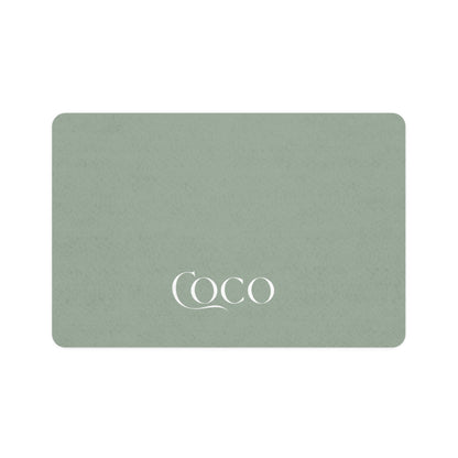 Soft sage rectangle personalized pet food mat with the name Coco in white serif lettering