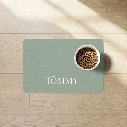 Soft sage personalized pet food mat with a personalized name and a food bowl in natural light