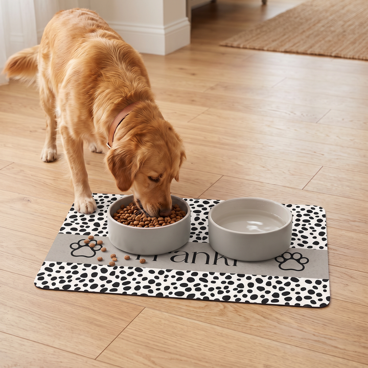 Golden retriever eating from a bowl on a spotted paw personalized pet food mat