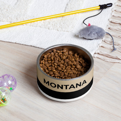 Tan and black two-tone personalized dog bowl filled with kibble on a rug next to a pet toy