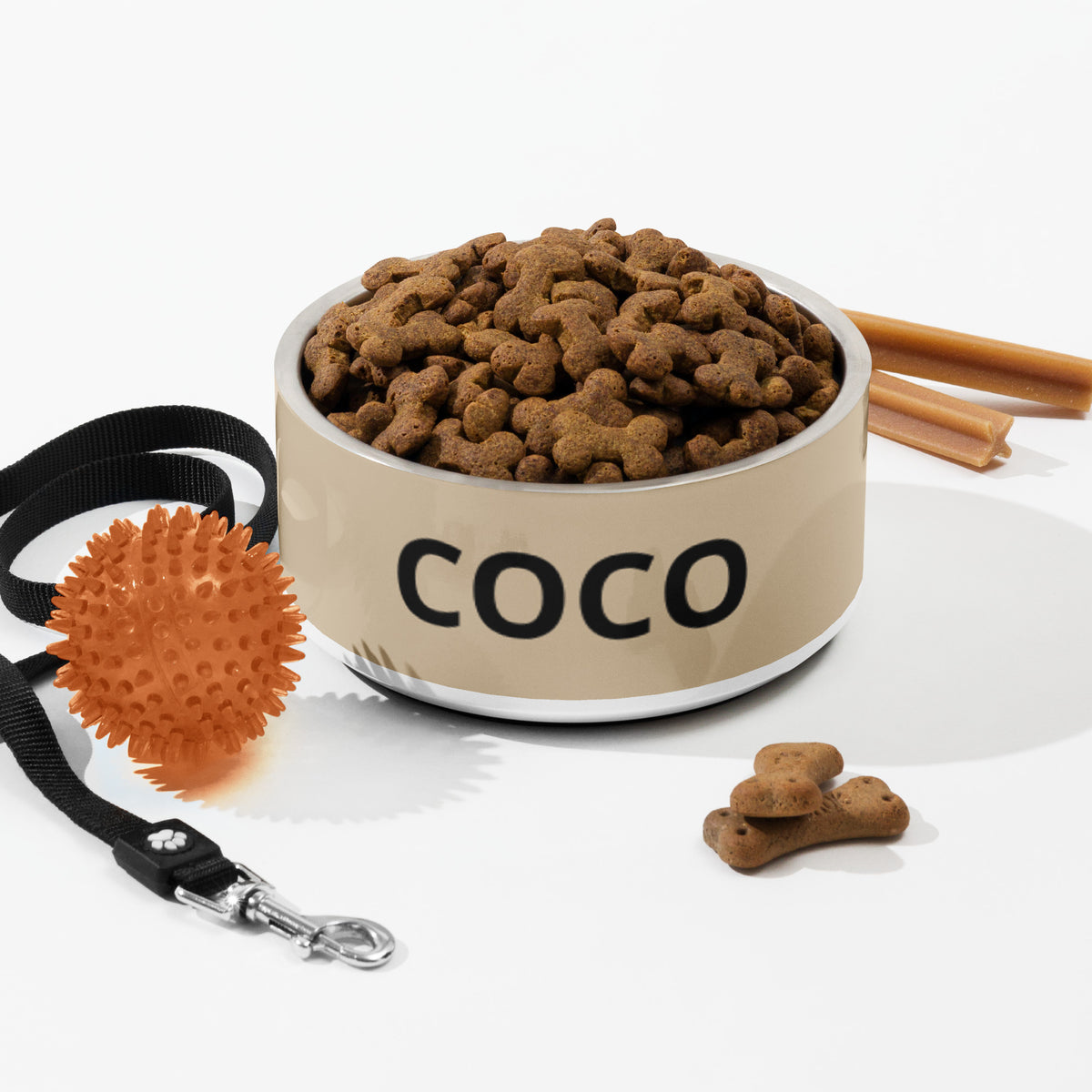 Large tan modern personalized dog bowl with kibble, a leash, a ball and dog treats