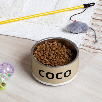 Tan modern personalized dog bowl filled with kibble on a rug next to a pet toy
