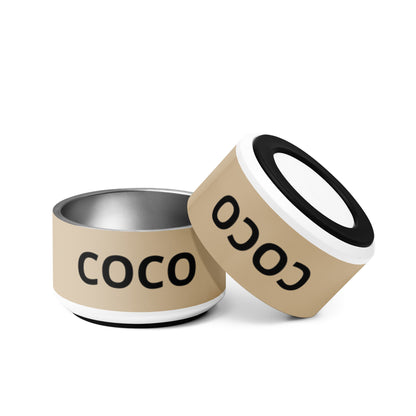 Two tan modern personalized dog bowls with the name Coco, one tilted to show the rim
