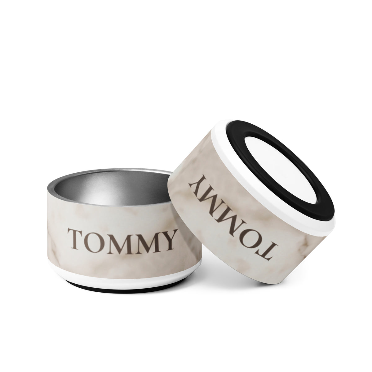 Two 18 oz white marble personalized dog bowls with the name Tommy, one tilted to show the non-slip base